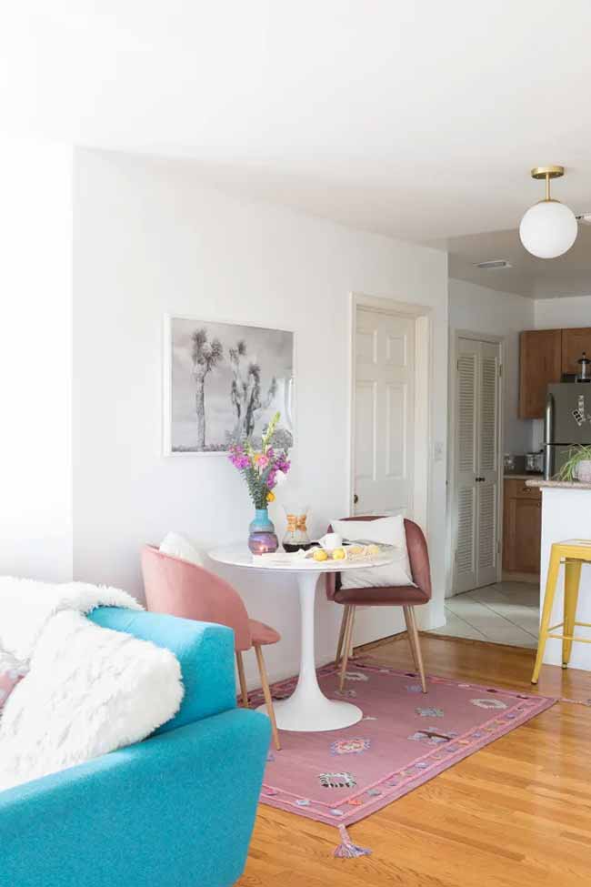 A circular white table paired with blush pink and maroon chairs gives this modern space a polished yet relaxed vibe.