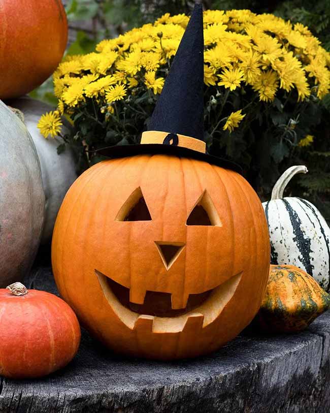 A pointy witch hat sits on top of this happy jack-o'-lantern, making it look ready for trick-or-treating.