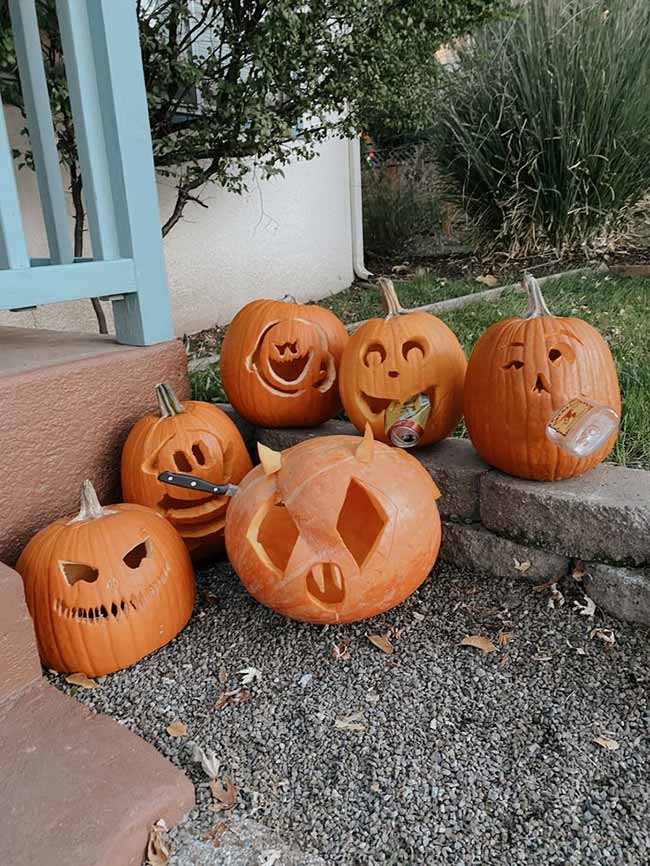 This funny group of pumpkins shows some creative pumpkin carving ideas, like one with a knife in its head and another with a can in its mouth.