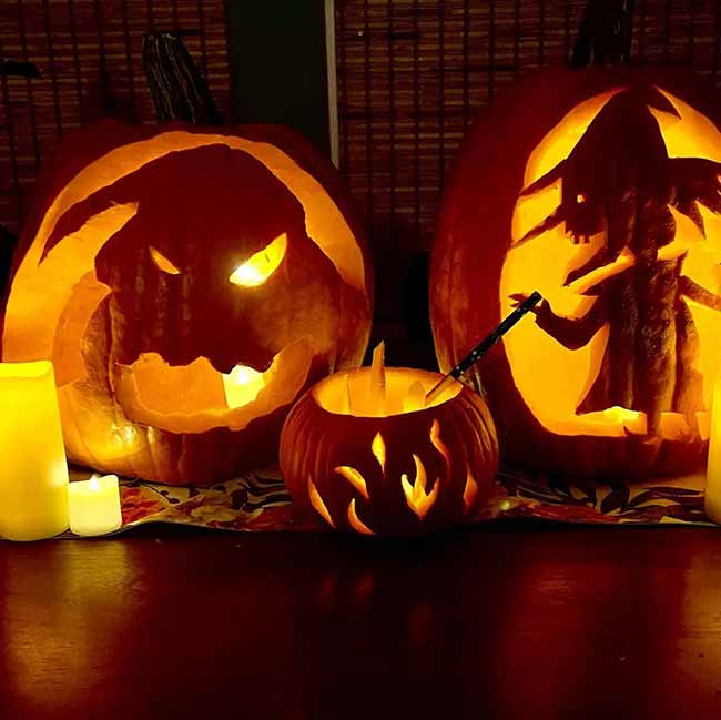 Here we have a very detailed pumpkin carving of a witch stirring her cauldron, sitting next to a monster-faced jack-o'-lantern.
