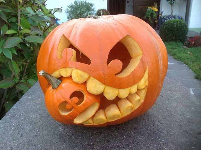 In a funny twist, this large, angry-looking pumpkin is carved to look like it's eating a smaller, terrified one.