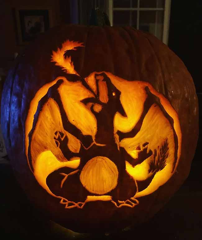 This incredible pumpkin carving showcases the Pokémon Charizard, breathing fire with its wings spread wide. The detailed etching makes the character glow.