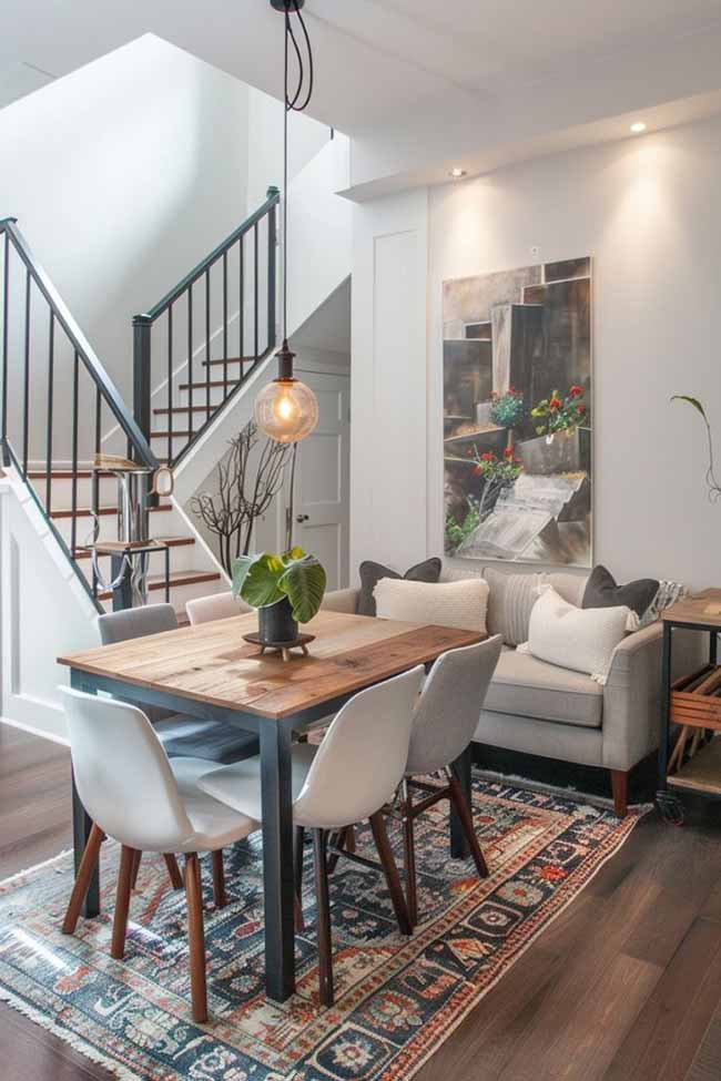 Dining chairs don’t always have to match. Slide a small loveseat against the wall and suddenly the whole area feels more relaxed. It’s comfortable, cozy, and makes you want to linger after dinner. An area rug under the table can tie everything together.
