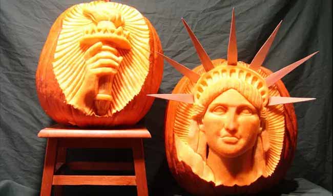 These aren't your average jack-o'-lanterns—they are incredibly detailed pumpkin sculptures of the Statue of Liberty. You can see her face on one and her hand holding the torch on the other.