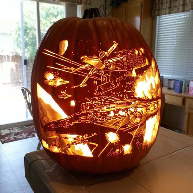 What an epic pumpkin carving! This large pumpkin shows a detailed scene from Star Wars, including spaceships and explosions.
