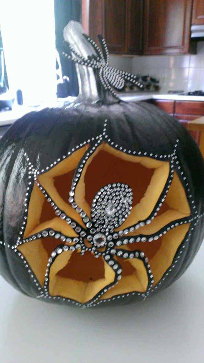 This elegant pumpkin has a spiderweb carved into its side, with shiny rhinestones outlining the design.