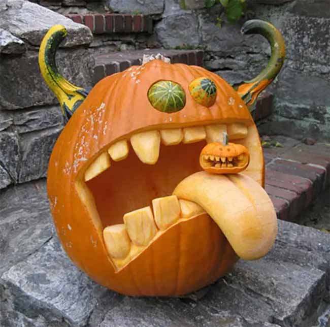 What a crazy monster! This pumpkin carving has gourds for horns and a long pumpkin tongue sticking out from its big, toothy mouth.