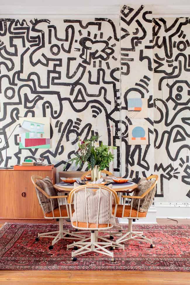 A bold black-and-white mural with abstract shapes instantly gives the dining area a creative, lively feel.